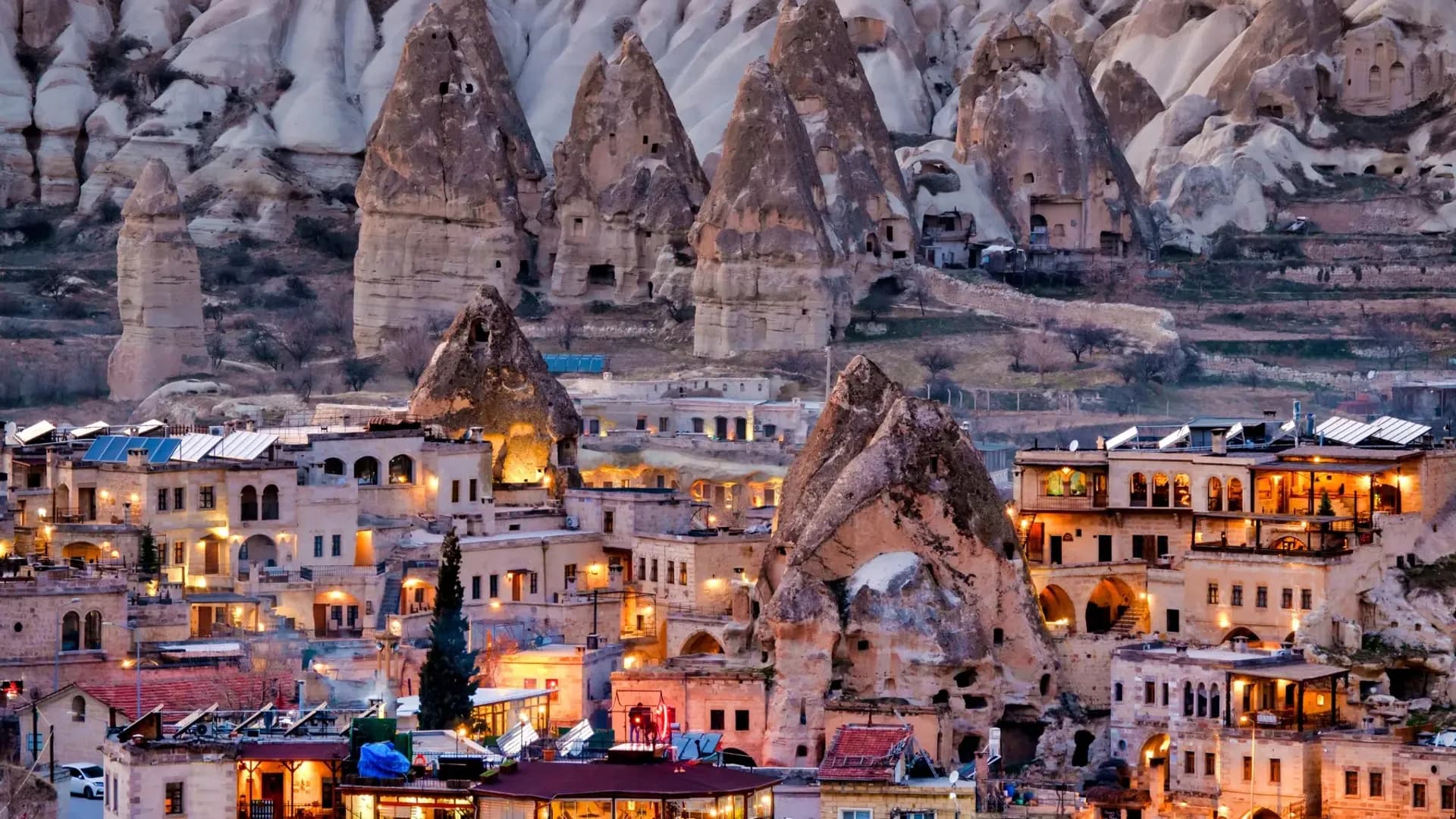 Illuminated buildings beneath pointed rock formations
