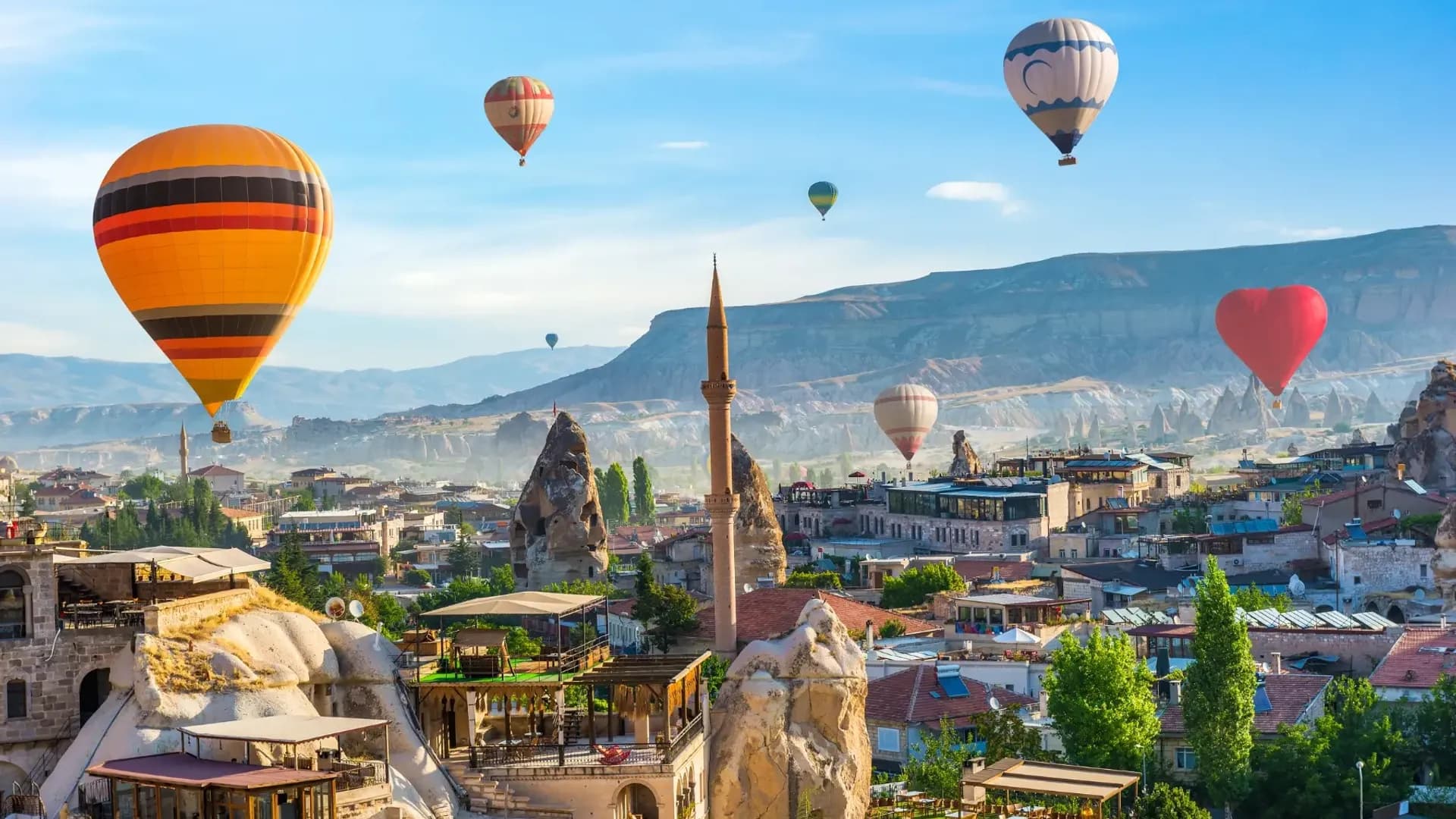 Hot-air balloons above a rocky town