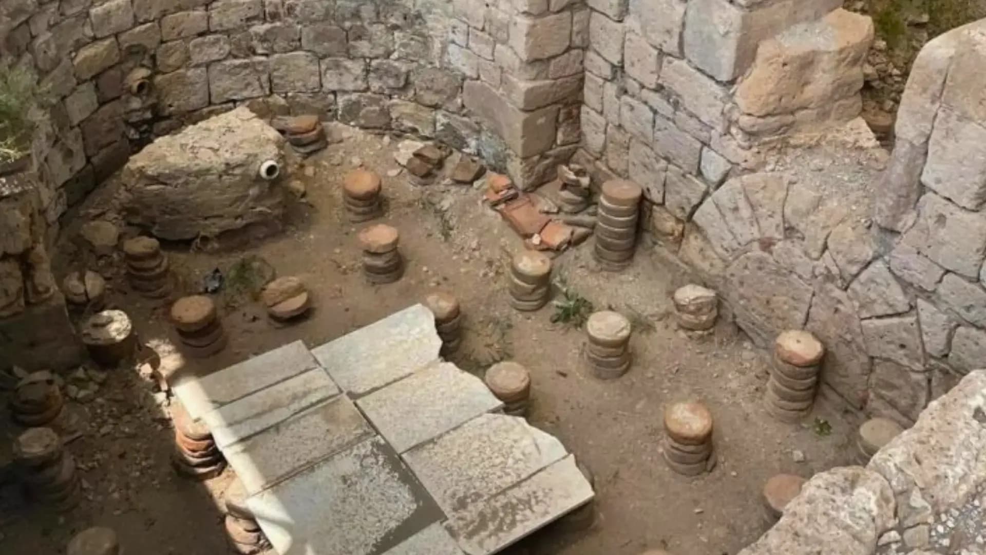 Stone foundations and clay vessels in an excavation