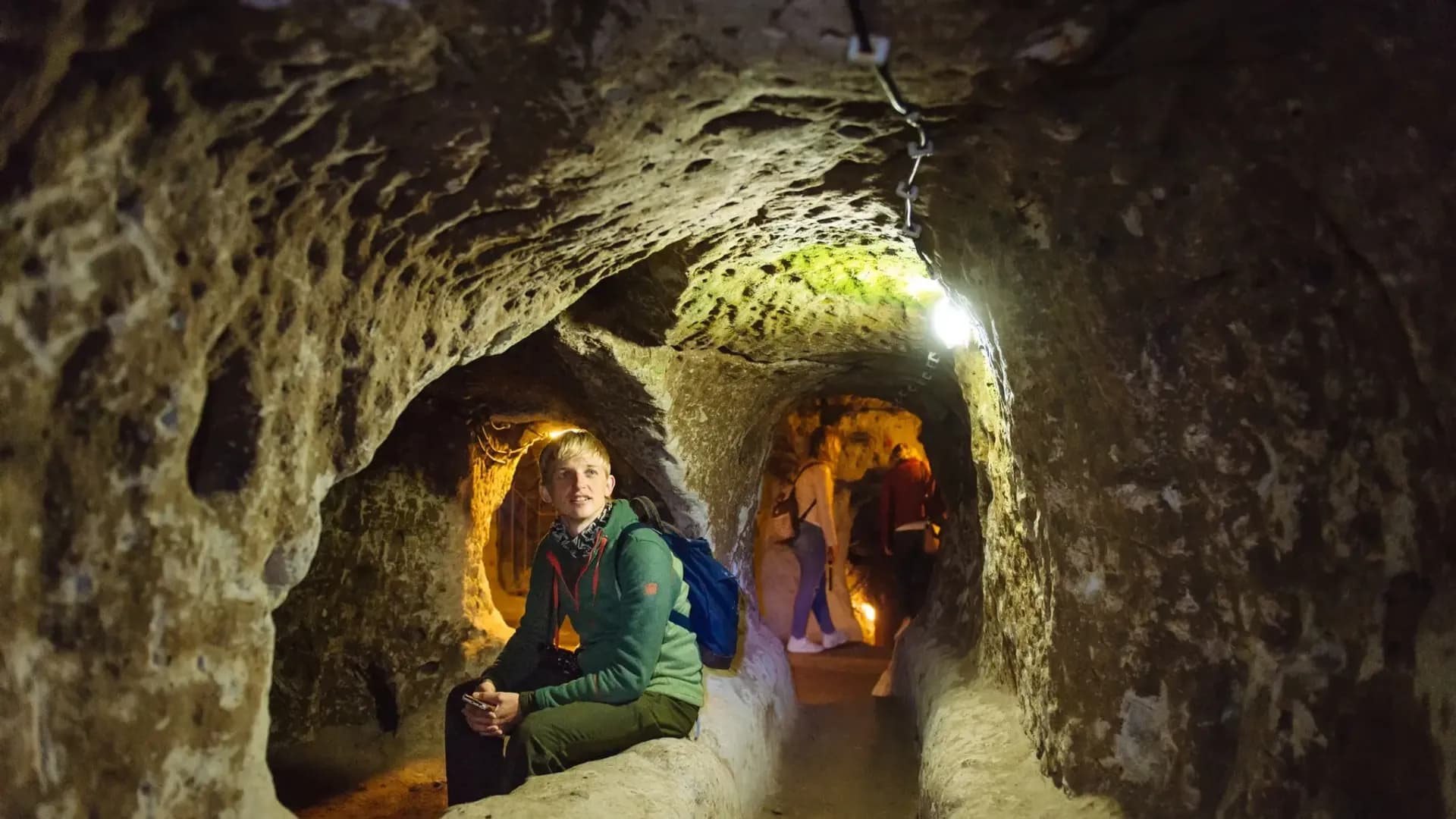 Visitor beside a curved underground passage