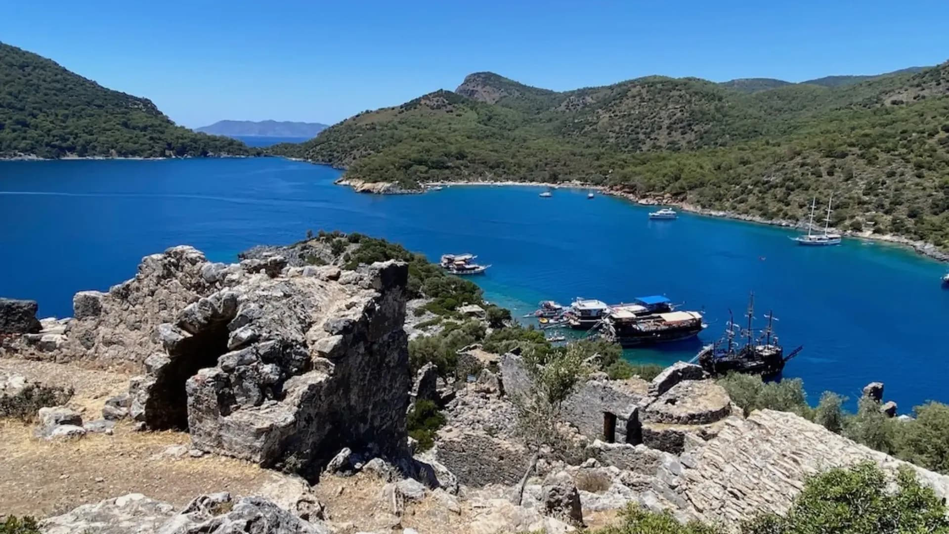 Steinruinen mit Blick auf eine blaue Bucht