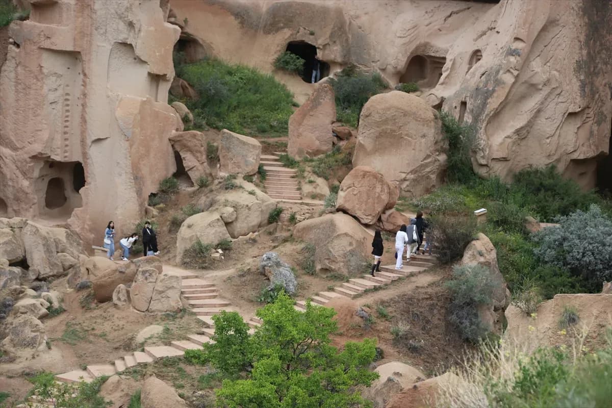 Besucher wandern zwischen geschnitzten Felskammern