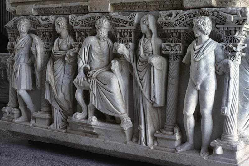 Geschnitzte Figuren auf einem alten Steinsarkophag