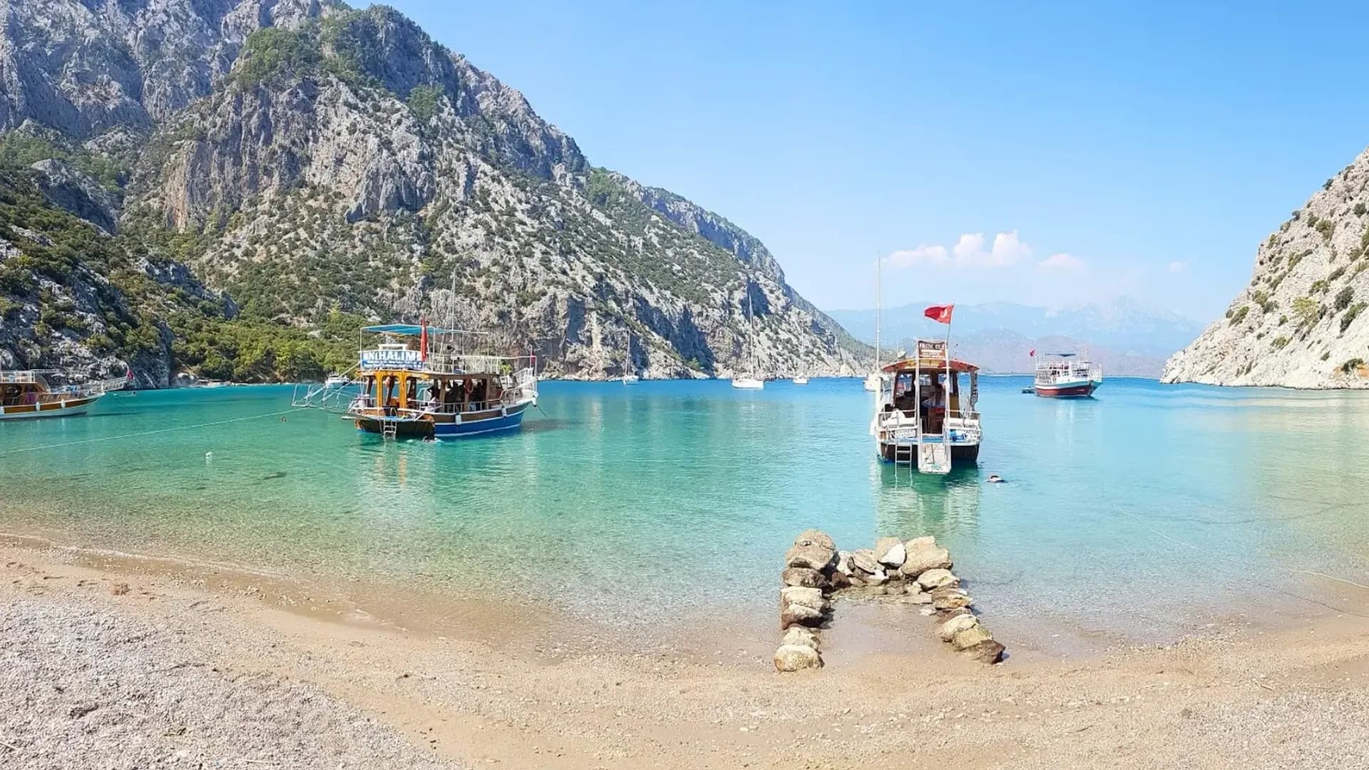 船只停泊在苍白的卵石海滩旁