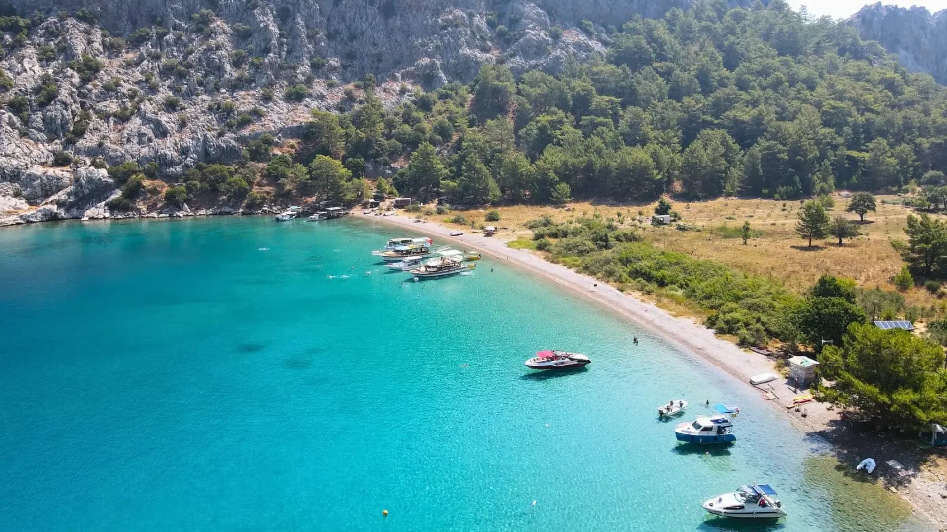 Boote neben einer geschwungenen türkisfarbenen Bucht