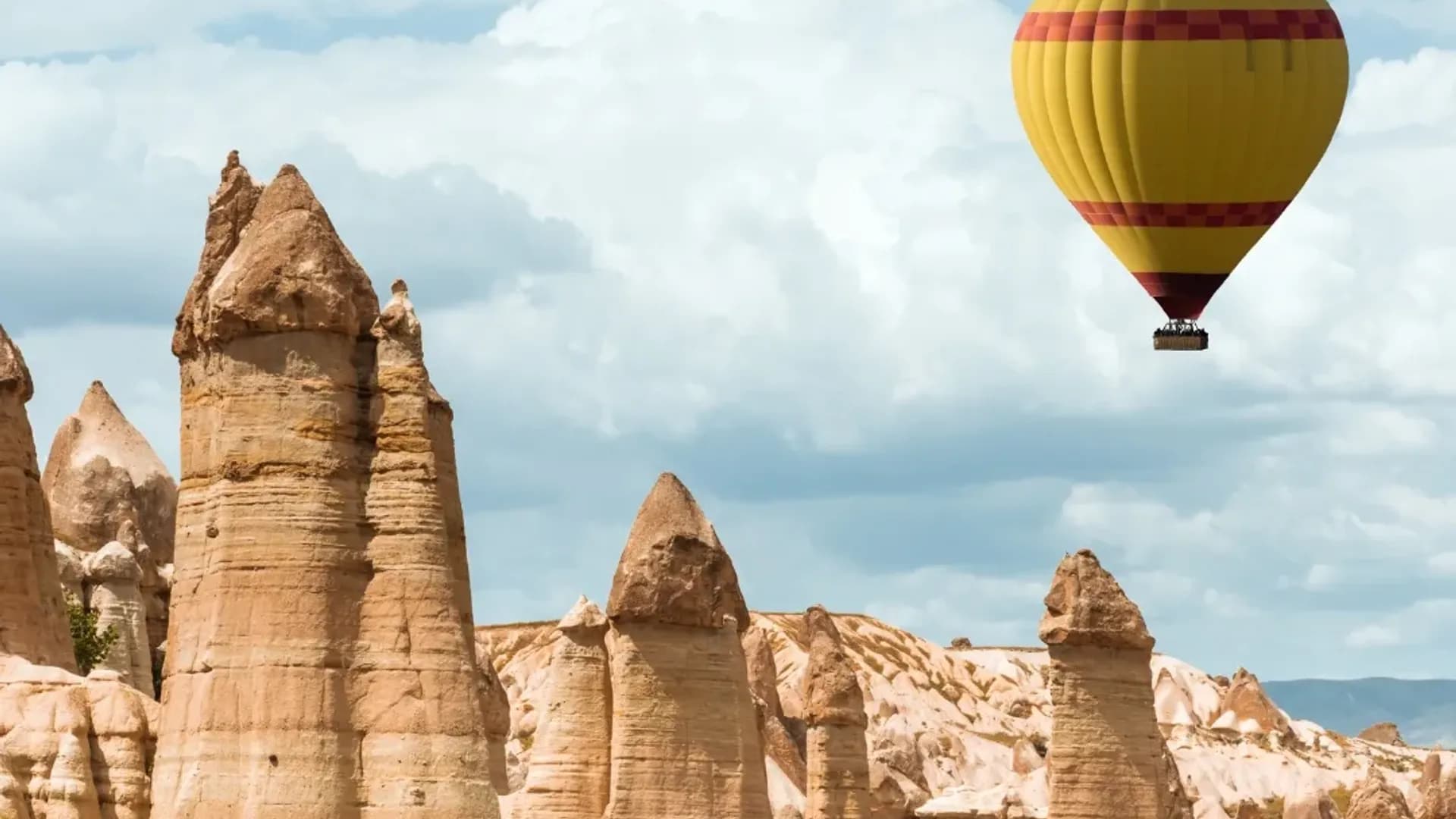 Heißluftballon neben hohen Felssäulen