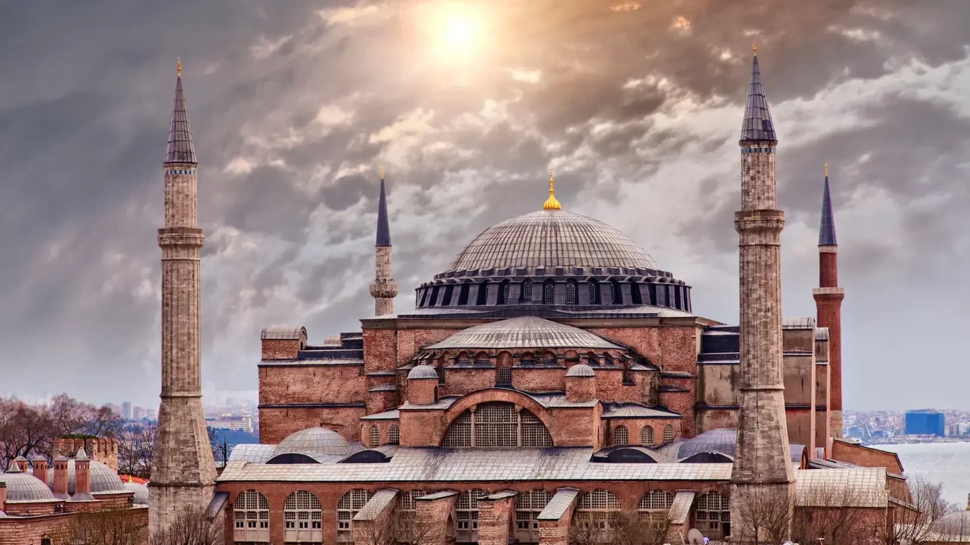 Domed building and minarets beneath dramatic clouds