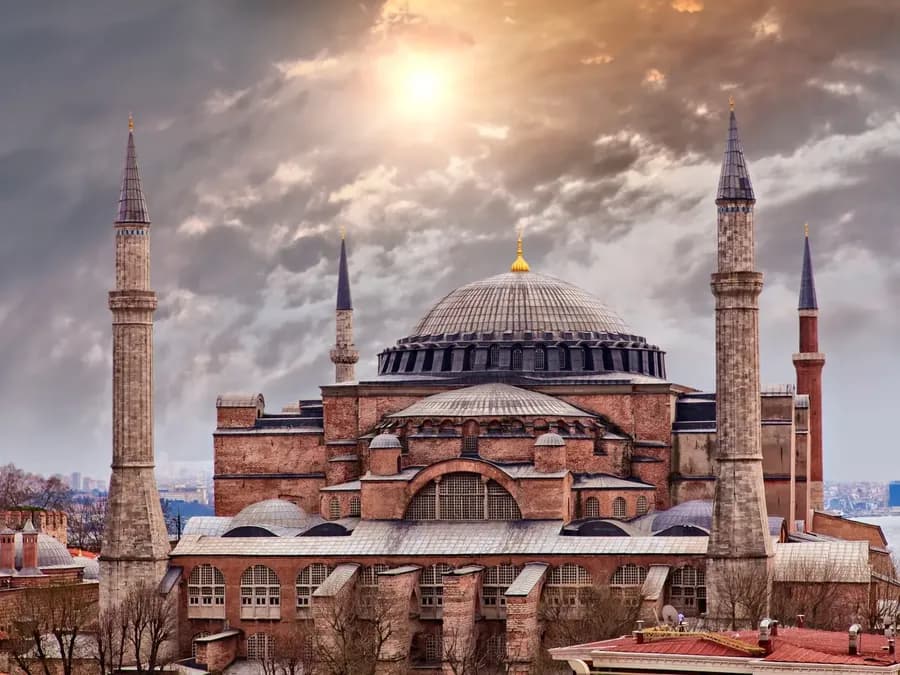 Domed building and minarets beneath dramatic clouds