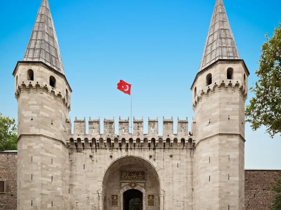 Turkish flag above a stone gateway with two towers