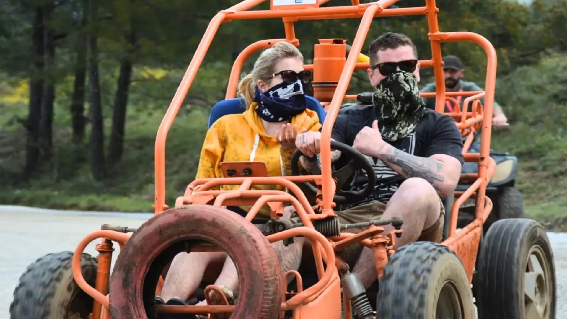 Zwei Fahrer in einem orangefarbenen Buggy