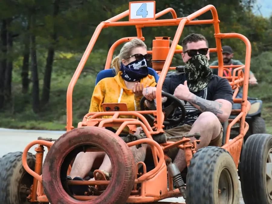 Zwei Fahrer in einem orangefarbenen Buggy