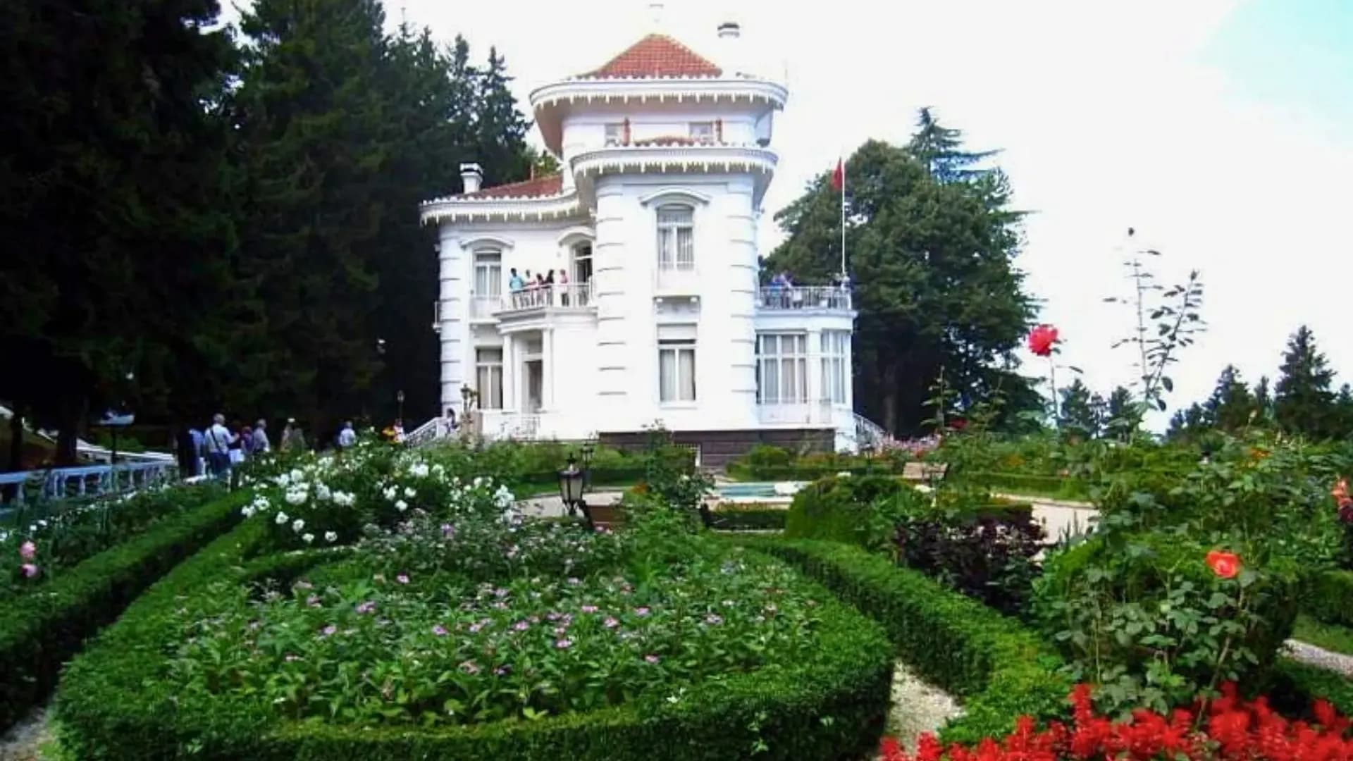 White mansion surrounded by a landscaped garden