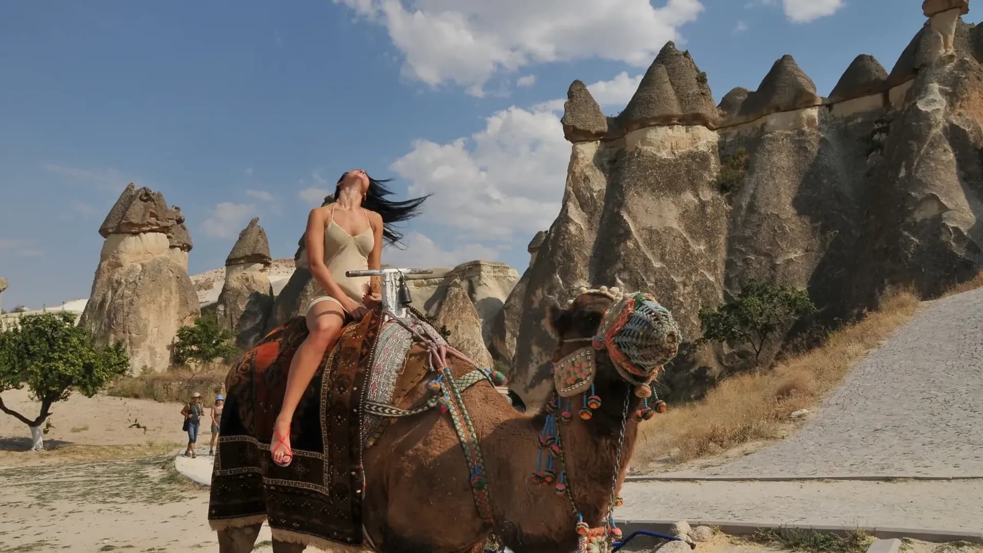 Camel rider beside tall rock formations