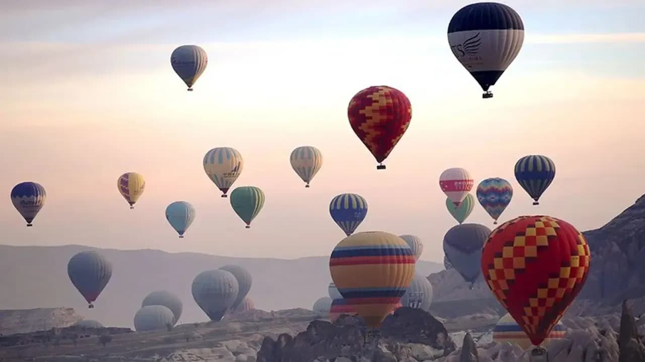 Luftballons über einer nebligen Landschaft