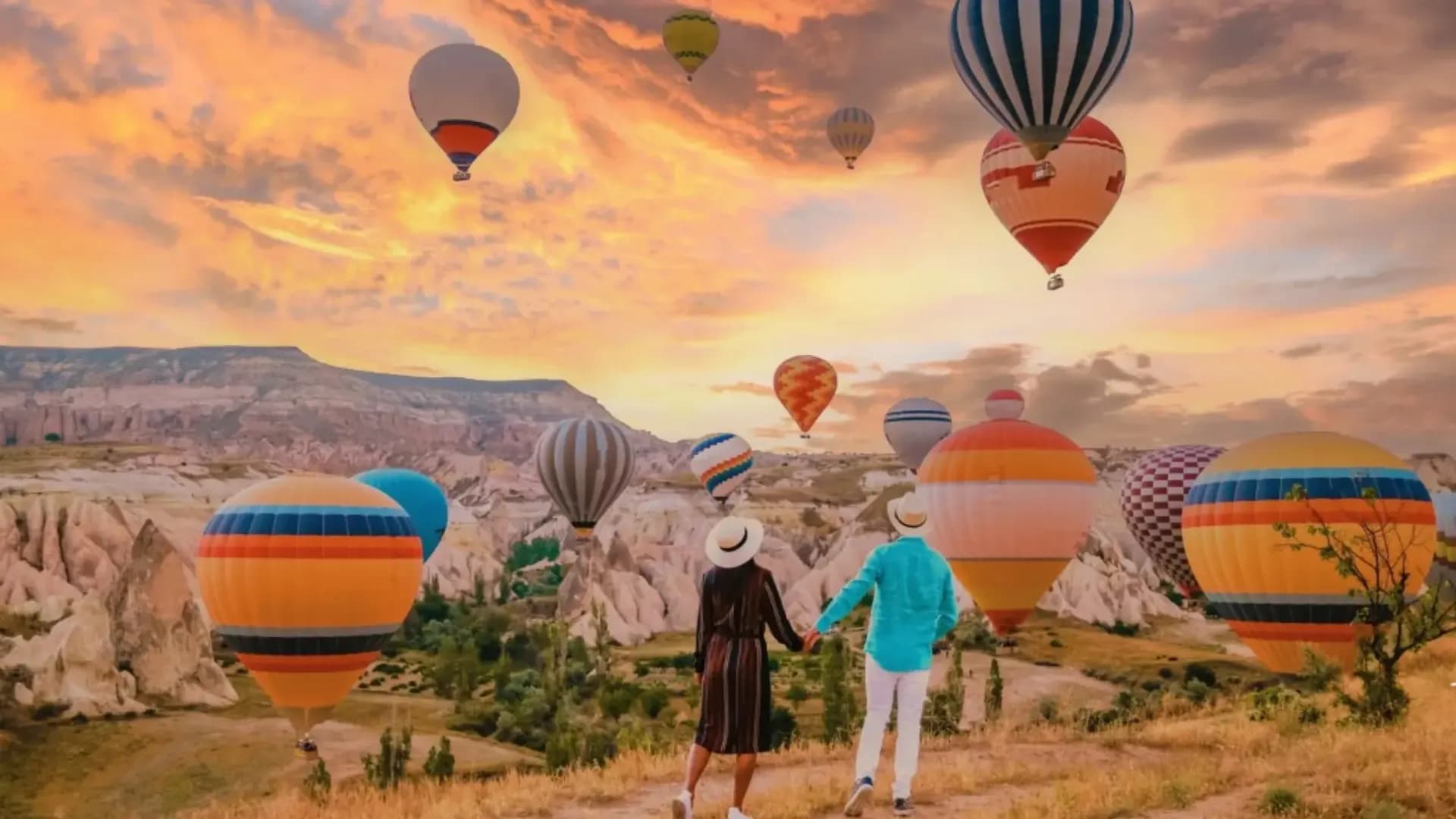 Besucher beobachten Luftballons neben Zelten