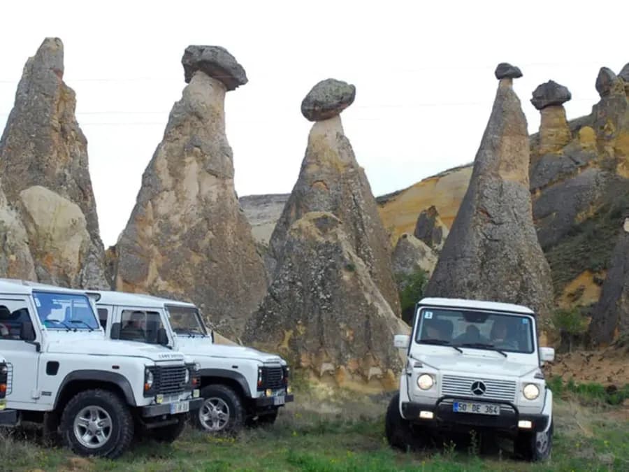 Off-road vehicles beside tall rock formations