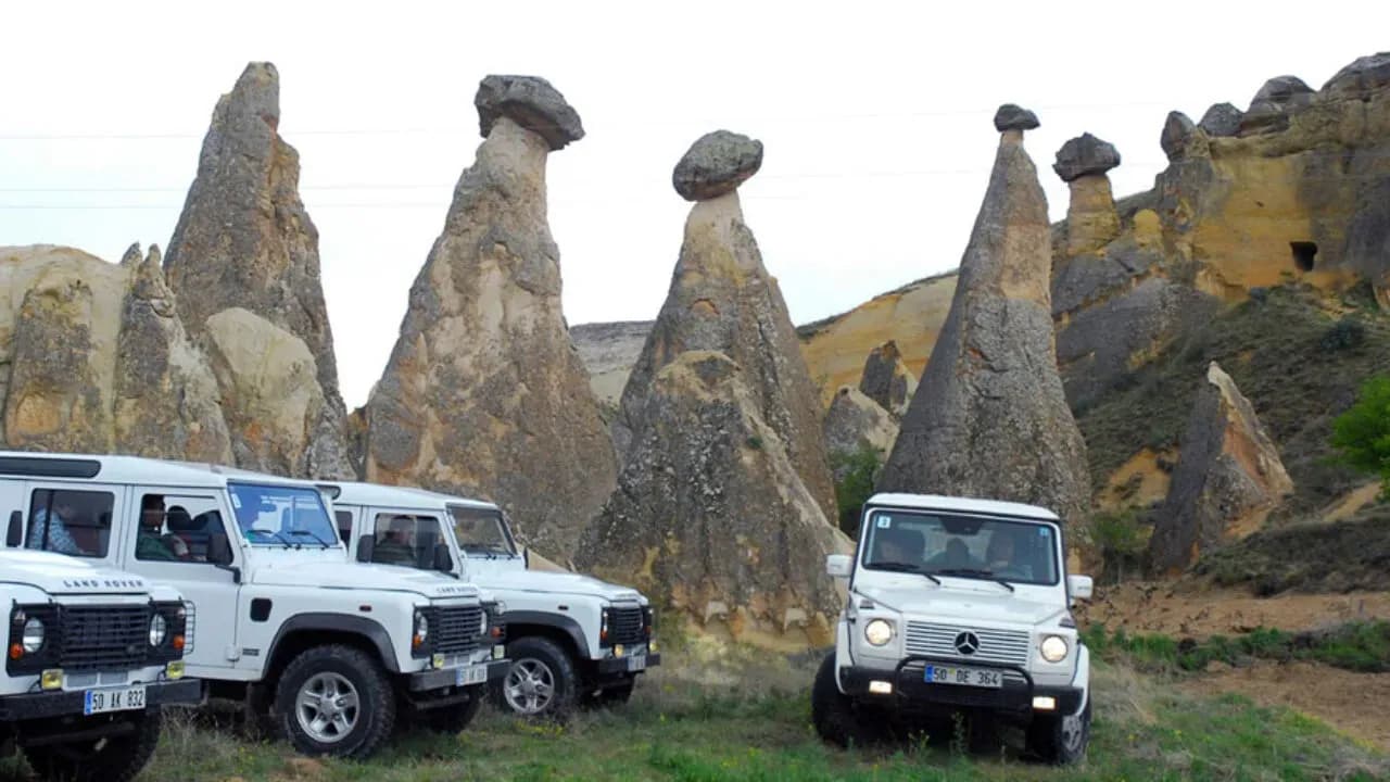 Off-road vehicles beside tall rock formations