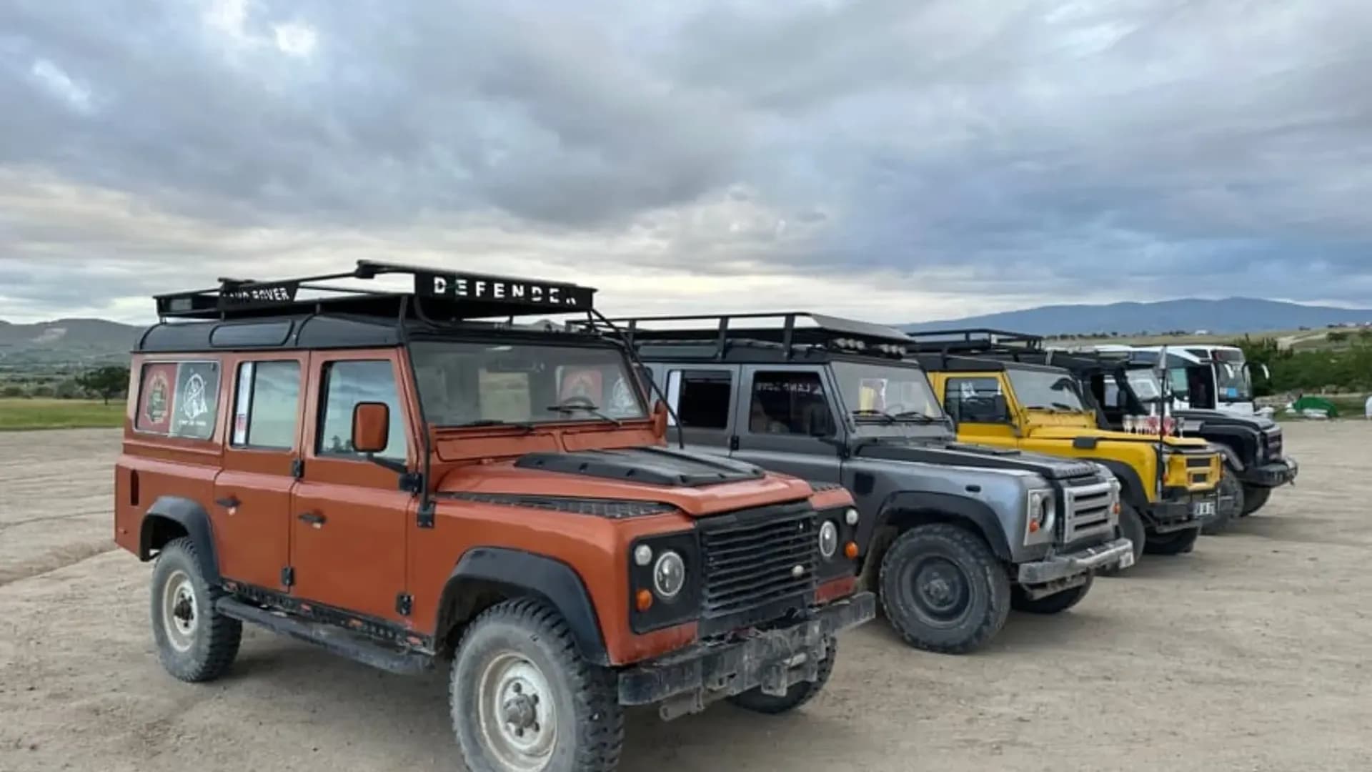 Off-road vehicles under a cloudy sky