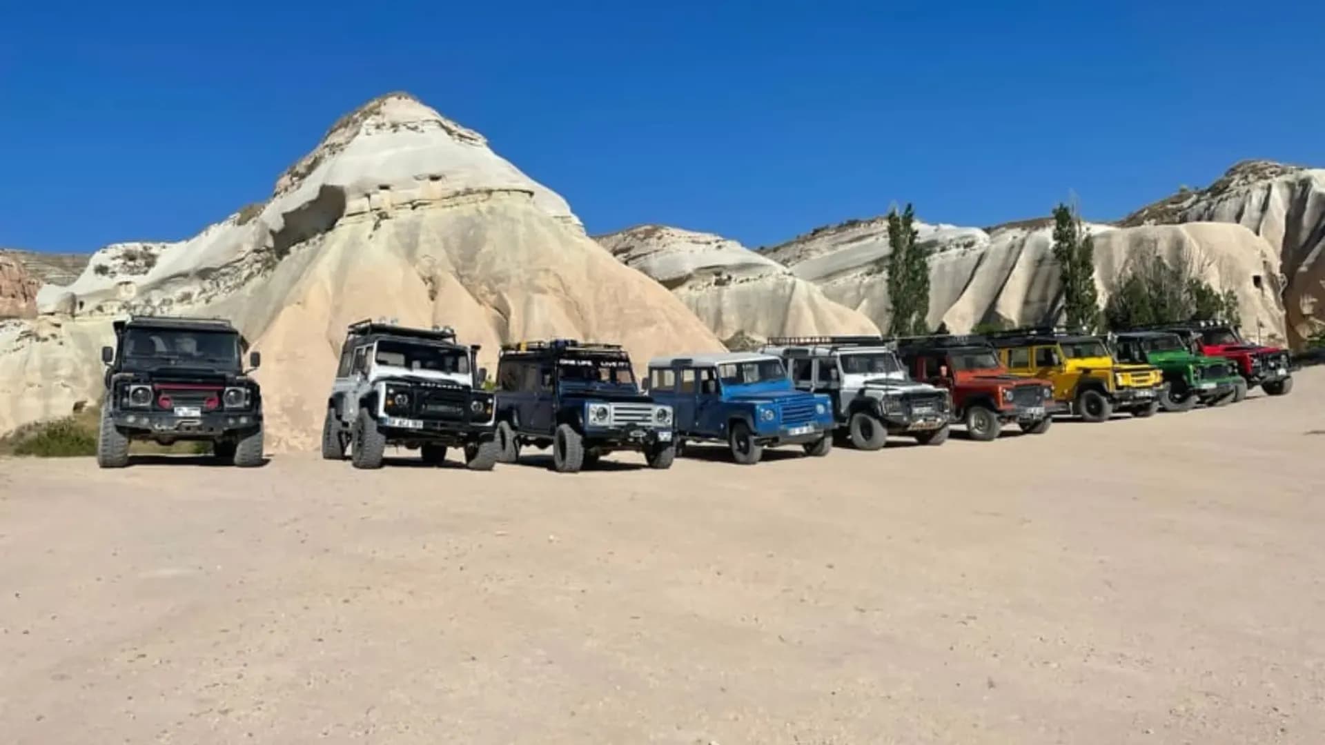 Off-road vehicles beside pale rock formations