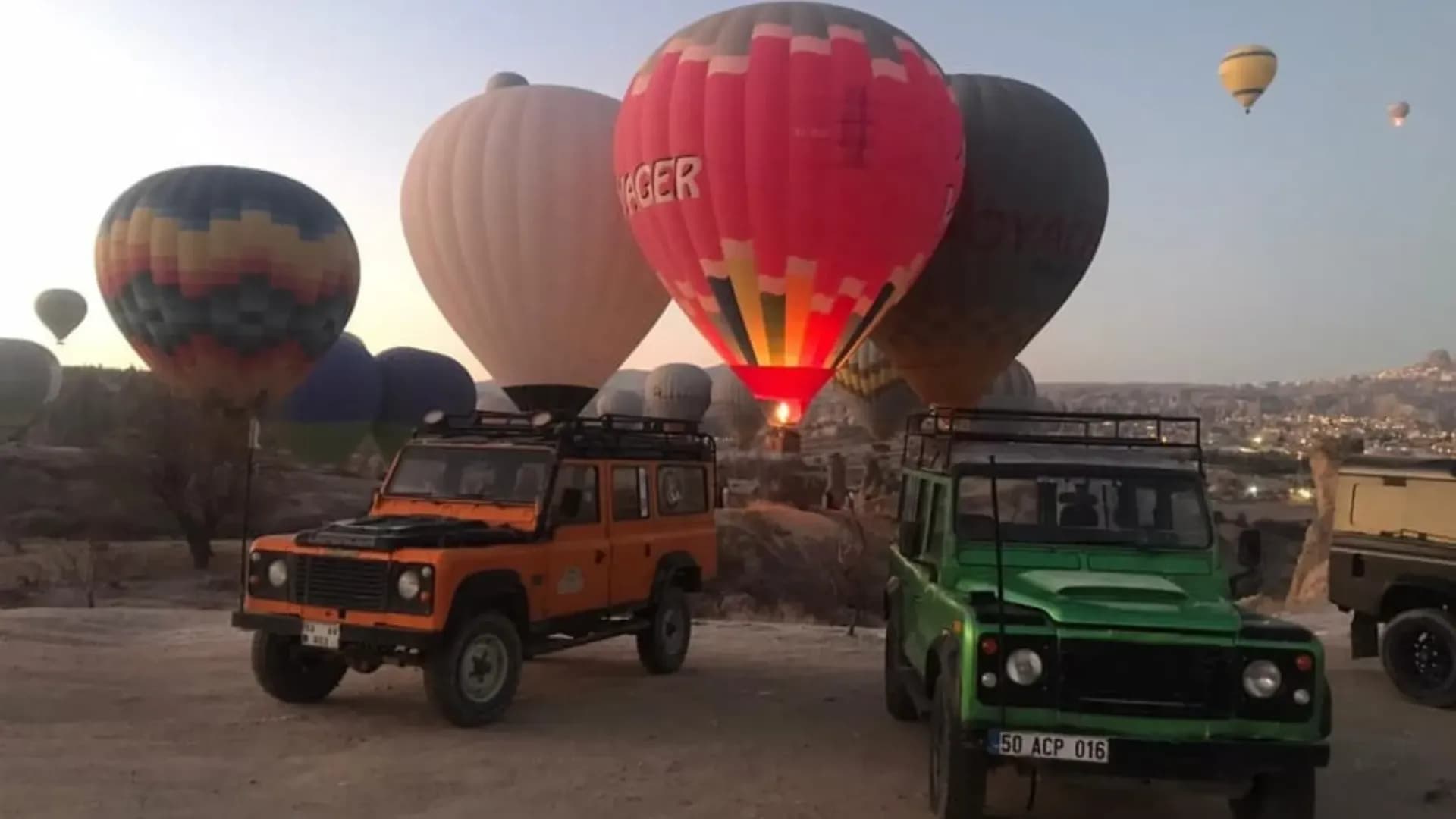 Off-road vehicles and balloons in evening light