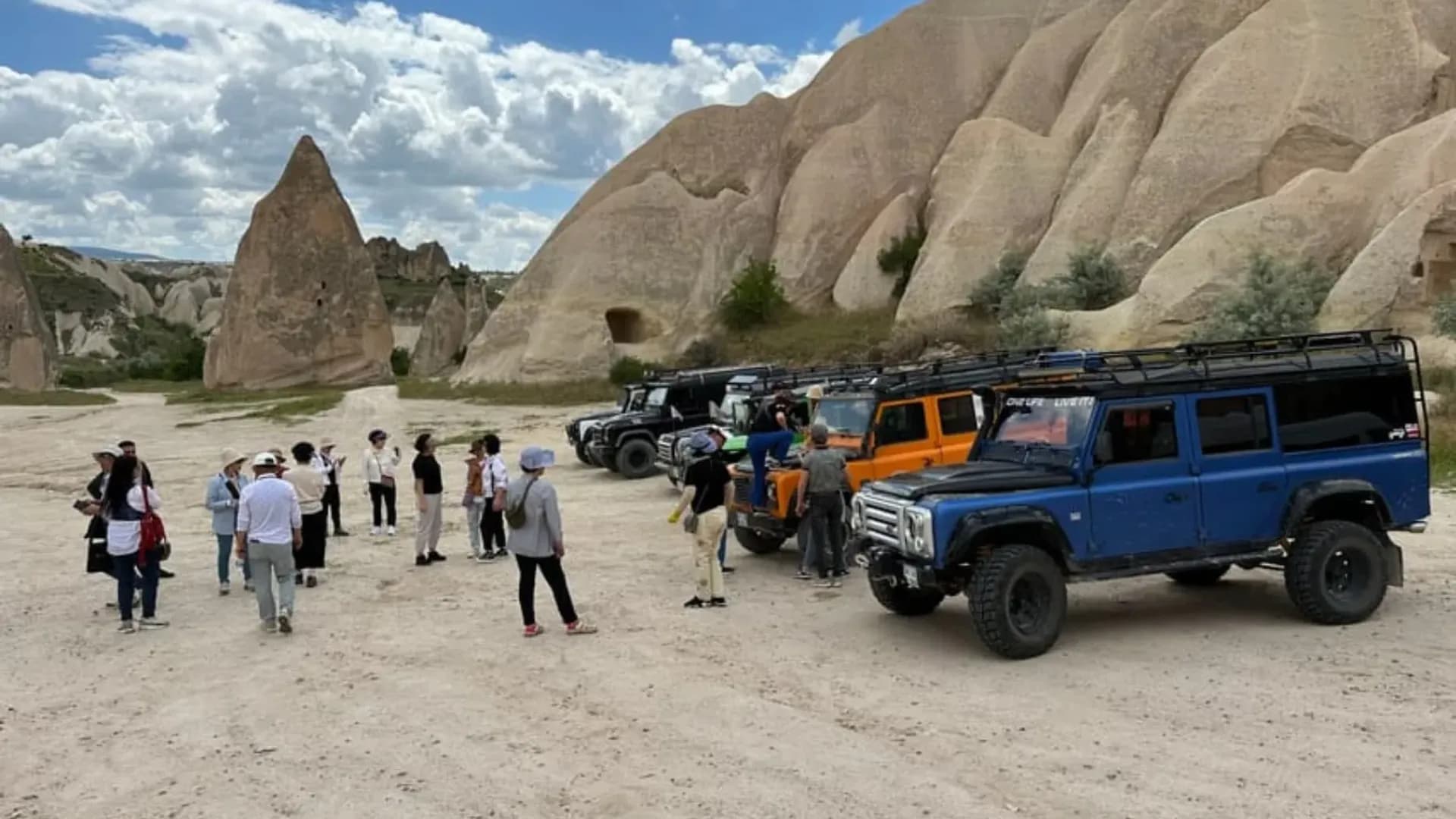 Vehicles and visitors in a rocky valley