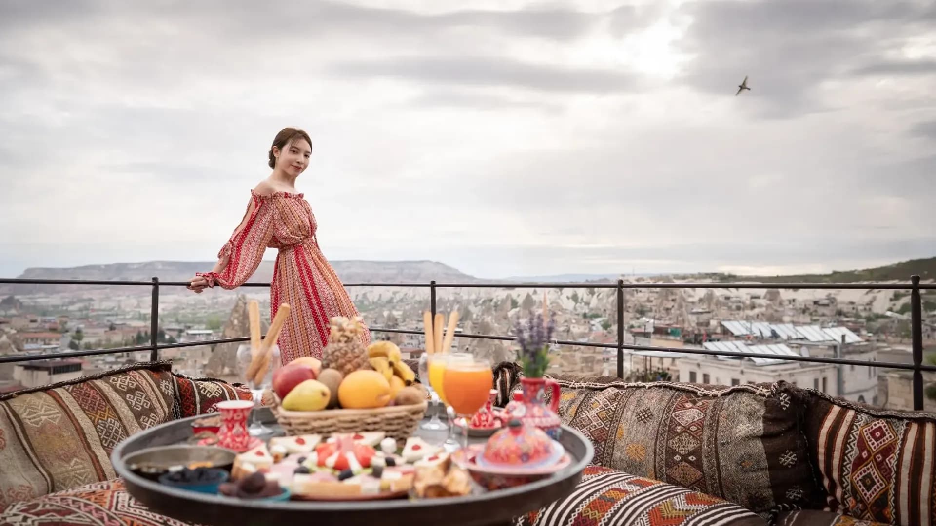 Food on a terrace table overlooking buildings