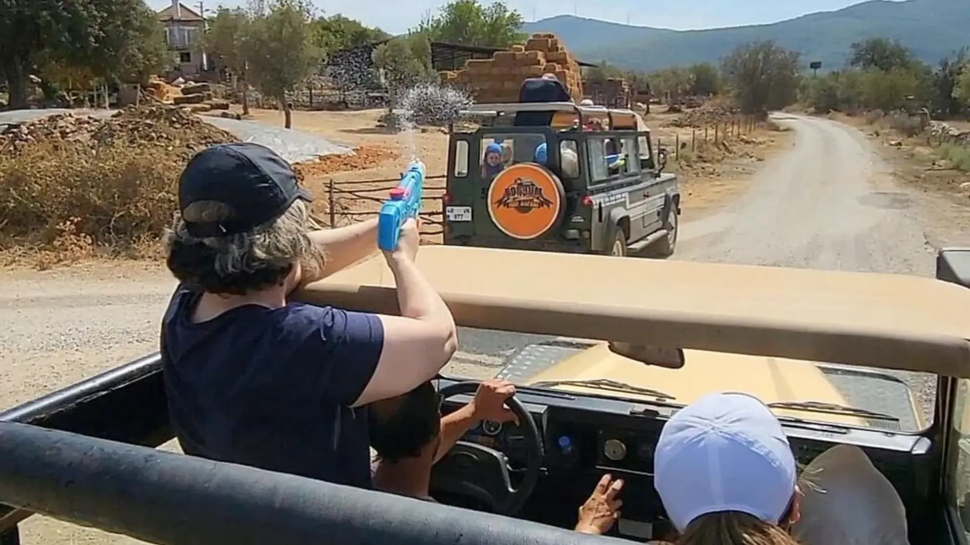 Passagiere fotografieren einen vorausfahrenden Jeep