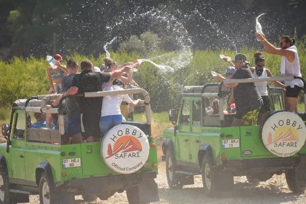 Passagiere versprühen Wasser zwischen Jeeps
