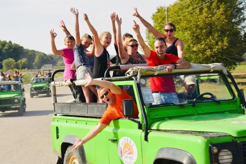 Passagiere heben ihre Arme in einem Jeep