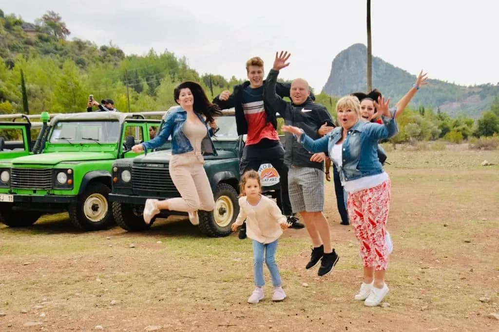 Besucher stehen neben grünen Jeeps
