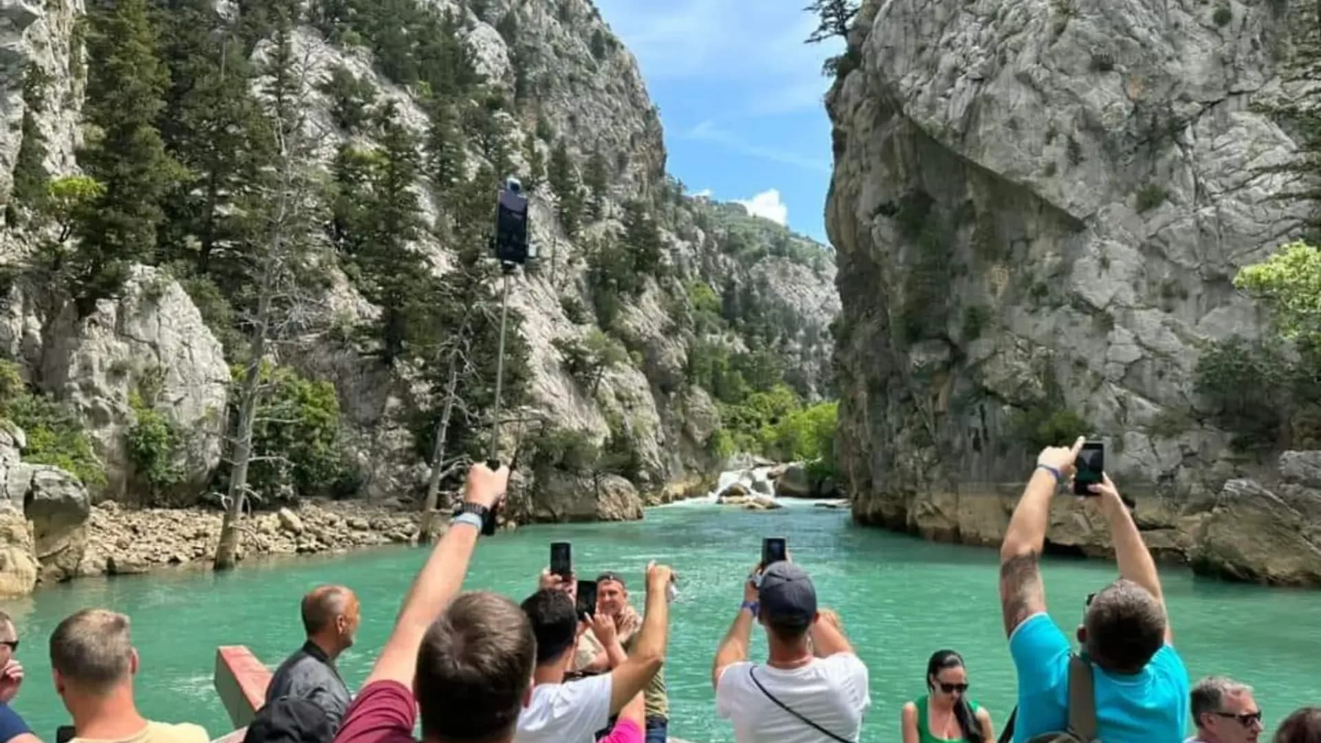 ركاب يصورون واديًا صخريًا من على متن قارب