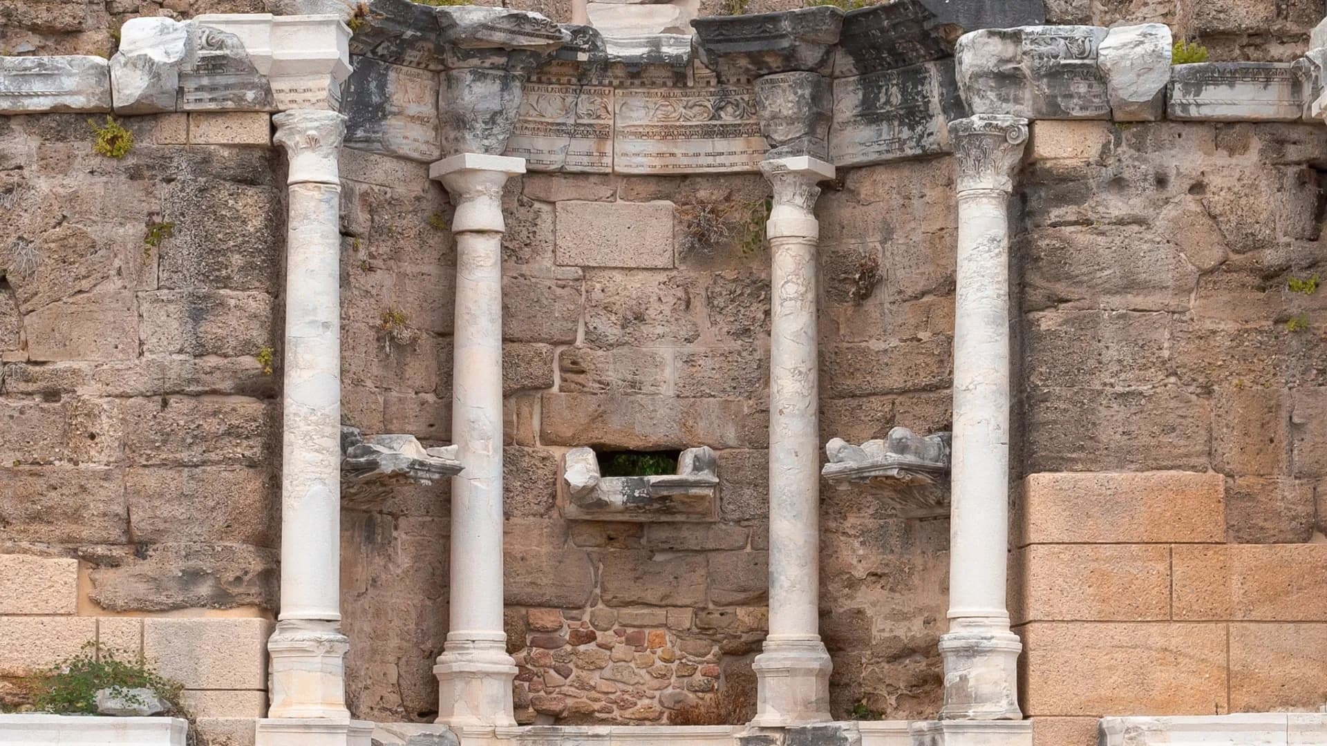 Carved stone facade with columns and a niche