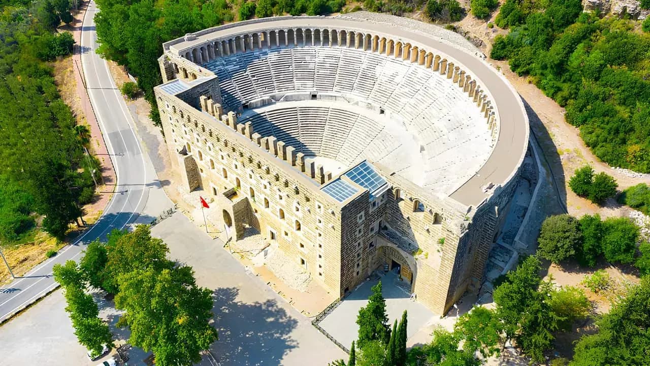 Ancient stone theatre surrounded by green trees