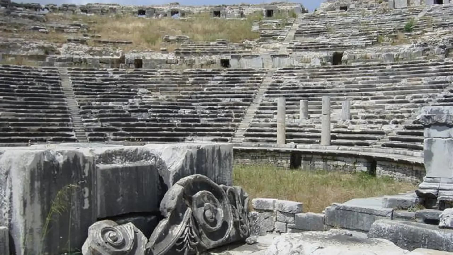 Carved stone capital beside ancient theatre seats