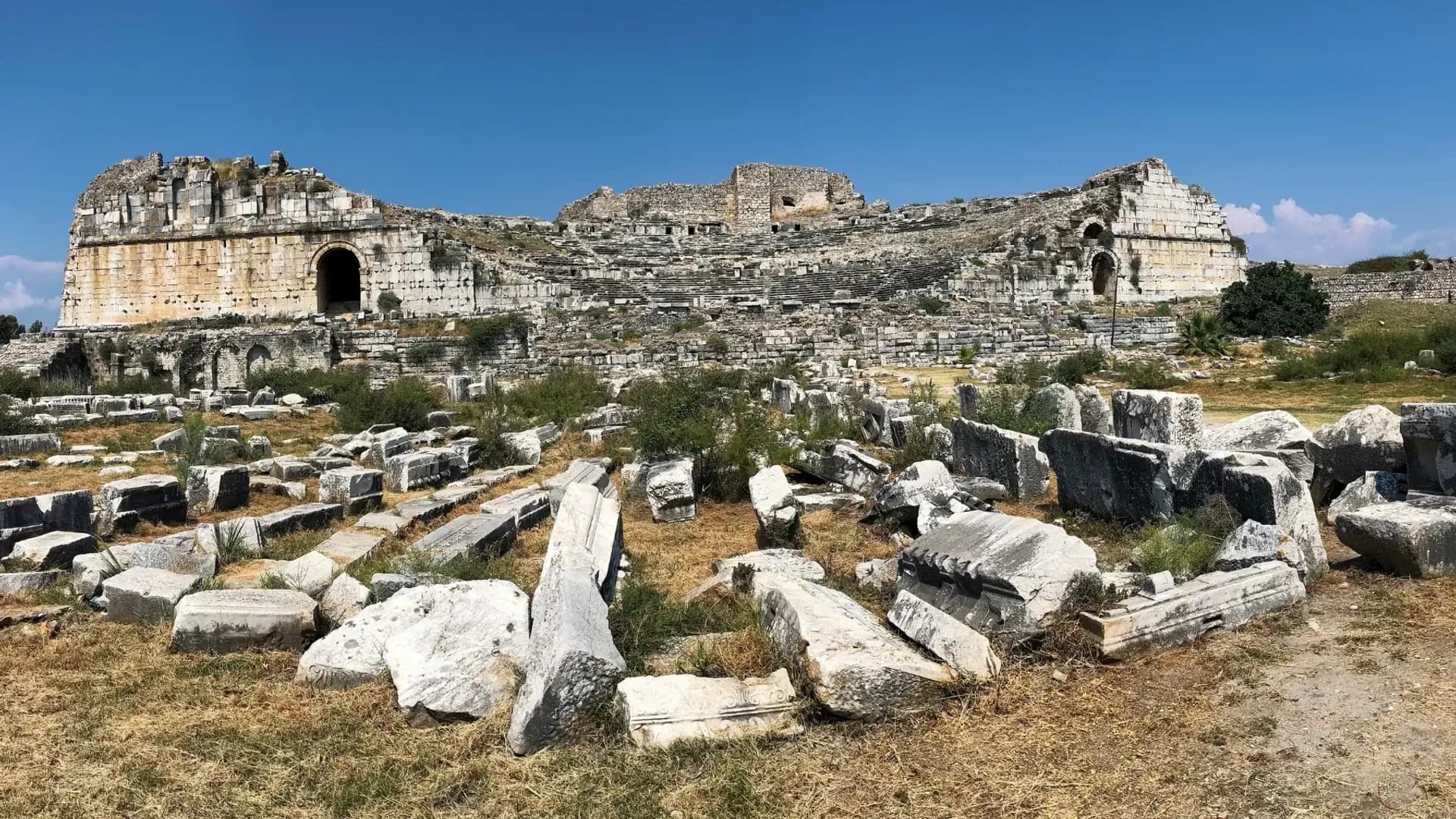 Scattered carved stones beside ancient ruins