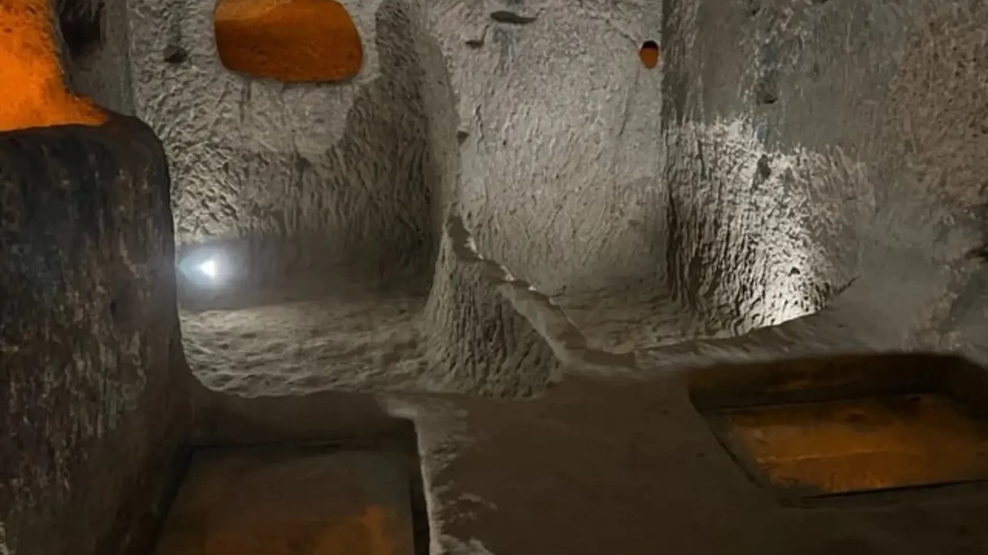 In den Fels gehauene Kammer mit kreisförmigem Steineingang
