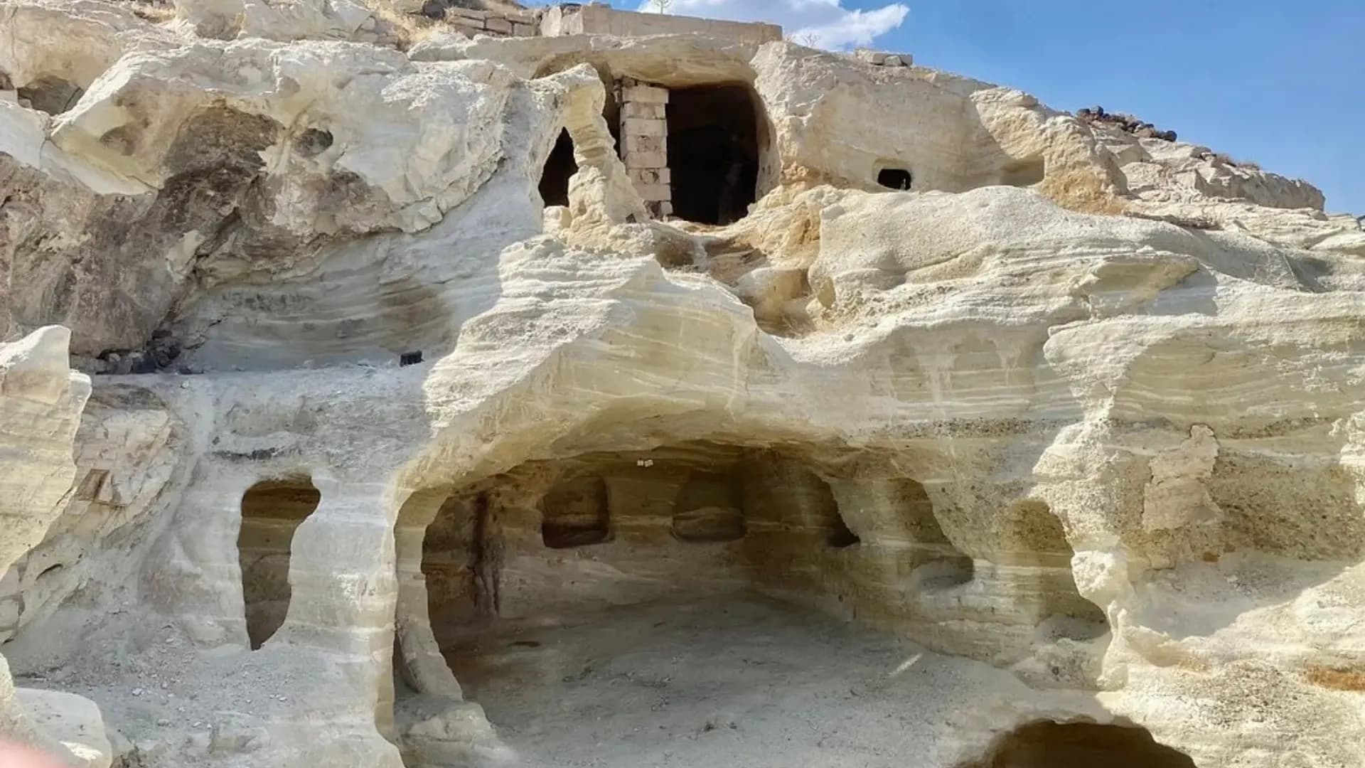 In den Fels gehauene Räume unter blauem Himmel