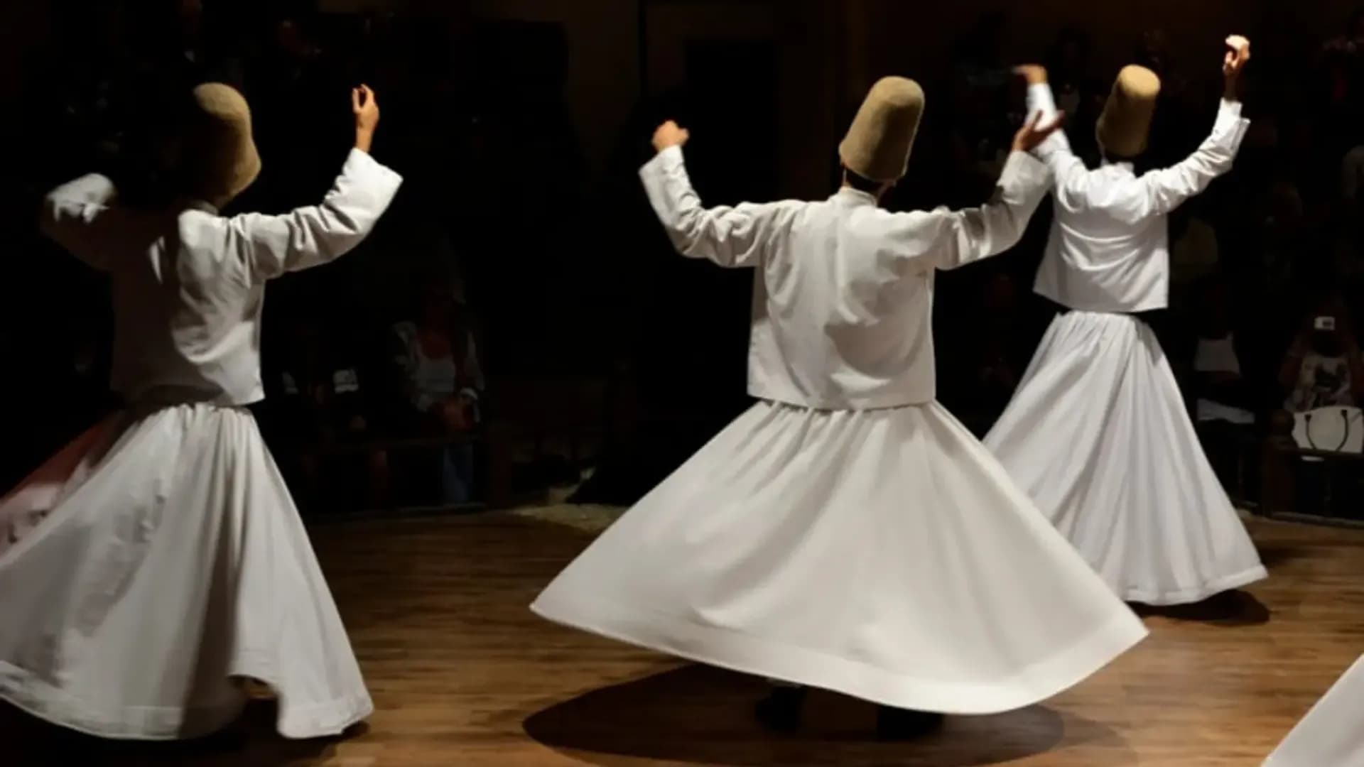 Two whirling performers in a hall